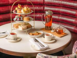 stół z talerzami jedzenia i filiżankami herbaty w obiekcie The Municipal Hotel Liverpool - MGallery w Liverpoolu