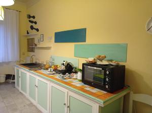 una cucina con bancone e forno a microonde di Casa della Ludo B&B a SantʼAntonino