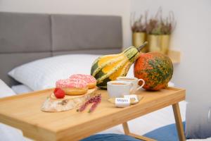 a table with doughnuts and a melon and a cup of coffee at Maya's Flats & Resorts 34 - Chmielna 73 in Gdańsk