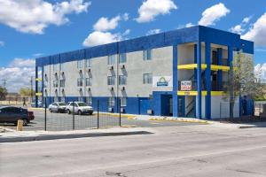 a blue building with cars parked in a parking lot at Days-Inn by Wyndham Albuquerque I-25 in Albuquerque