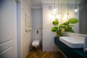 a bathroom with a sink and a toilet and a mirror at Maya's Flats & Resorts 34 - Chmielna 73 in Gdańsk