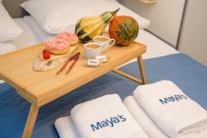a table with a tray of donuts and fruit on a bed at Maya's Flats & Resorts 34 - Chmielna 73 in Gdańsk