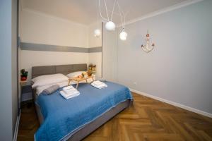 um quarto com uma cama azul com toalhas em Maya's Flats & Resorts 34 - Chmielna 73 em Gdansk