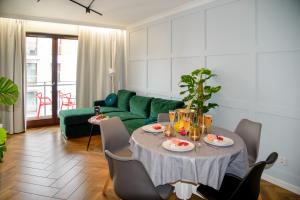 a living room with a table and a green couch at Maya's Flats & Resorts 34 - Chmielna 73 in Gdańsk