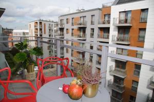 a table with fruit on a balcony with buildings at Maya's Flats & Resorts 34 - Chmielna 73 in Gdańsk