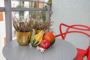 a table with a vase with fruit and flowers on it at Maya's Flats & Resorts 34 - Chmielna 73 in Gdańsk