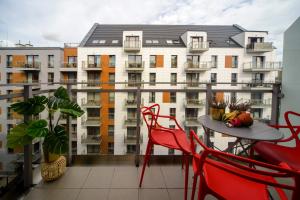 a balcony with a table and chairs and a building at Maya's Flats & Resorts 34 - Chmielna 73 in Gdańsk