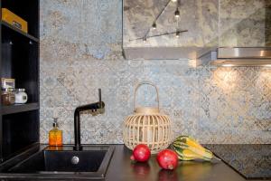 a kitchen counter with a sink and fruits on it at Maya's Flats & Resorts 34 - Chmielna 73 in Gdańsk