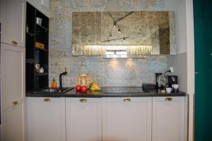 a kitchen with white cabinets and a counter top at Maya's Flats & Resorts 34 - Chmielna 73 in Gdańsk