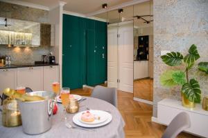 a kitchen and dining room with a table and a green door at Maya's Flats & Resorts 34 - Chmielna 73 in Gdańsk