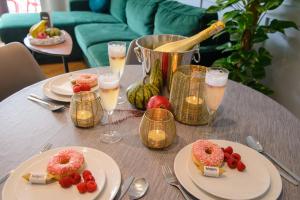 a table with plates of donuts and glasses of champagne at Maya's Flats & Resorts 34 - Chmielna 73 in Gdańsk