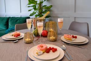 a table with plates of food and glasses of champagne at Maya's Flats & Resorts 34 - Chmielna 73 in Gdańsk