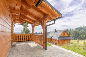 an exterior view of a wooden deck with a house at Malebný chalet Benešky in Velké Karlovice