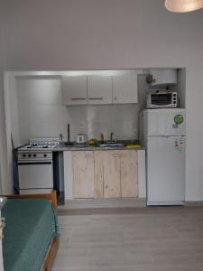 Una cocina con un refrigerador blanco y una estufa. en Kuka 2, en Villa Gesell