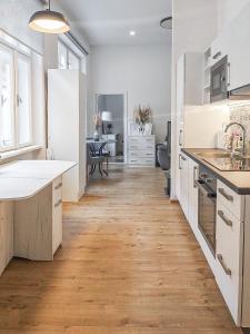 een keuken met witte kasten en een harde houten vloer bij Hlavna Apartment II Košice in Košice
