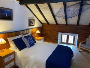 a bedroom with a large white bed with blue pillows at Loft in Getxo in Getxo