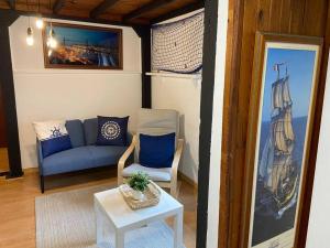 a living room with a blue couch and a table at Loft in Getxo in Getxo