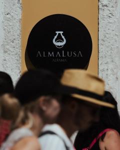 um grupo de pessoas usando chapéus em pé na frente de uma placa em AlmaLusa Alfama em Lisboa