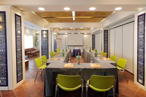 a conference room with a long table and green chairs at Hotel Oasi Di Kufra in Sabaudia