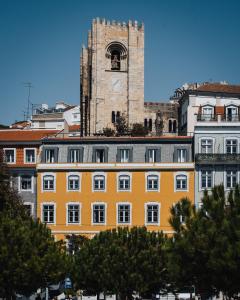 un grand bâtiment avec une tour d'horloge en arrière-plan dans l'établissement AlmaLusa Alfama, à Lisbonne