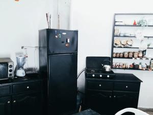 uma cozinha com um frigorífico preto e um fogão em Room in Guest room - Nadia chamber with lounge terrace em El Jadida