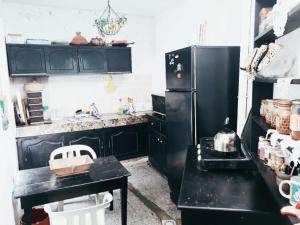 uma cozinha com armários pretos e um frigorífico preto em Room in Guest room - Nadia chamber with lounge terrace em El Jadida