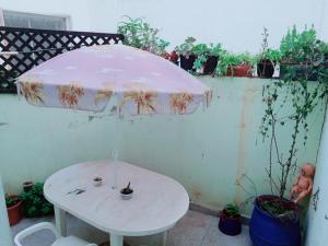 a white table with an umbrella on a patio at Room in Guest room - Nadia chamber with lounge terrace in El Jadida