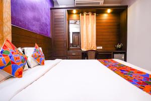 a bedroom with a large bed with colorful pillows at FabExpress MM Residency in Chennai
