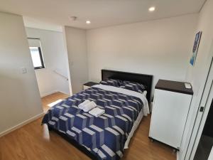 a bedroom with a bed with a blue and white comforter at Ermihome Studio in Sydney