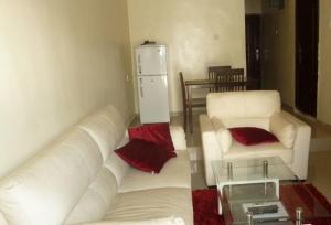 a living room with a white couch and a white refrigerator at Room in Lodge - Vision Serviced Apartments in Asaba