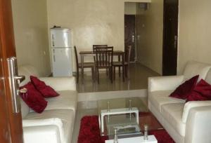 una sala de estar con 2 sofás blancos y una mesa. en Room in Lodge - Vision Serviced Apartments, en Asaba