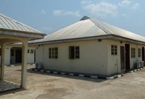 a white house with a metal roof at Room in Lodge - Vision Serviced Apartments in Asaba