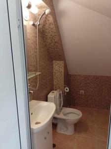 a small bathroom with a toilet and a sink at Цвят бяло in Sofia