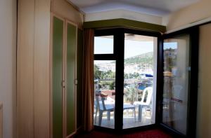 ein Zimmer mit Glastür und Blick auf einen Balkon in der Unterkunft Rıdvan Hotel in Cesme