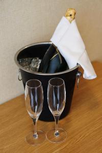 two wine glasses on a table with a bucket of wine at Hotel Reykjavík Centrum in Reykjavík