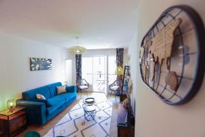 a living room with a blue couch and a mirror at Cozy along the river - downtown & terrace - 4 in Annecy