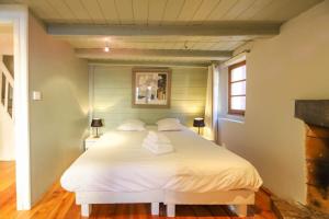 Un dormitorio con una cama blanca en una habitación. en La maison verte, en Annecy 33 fotos más