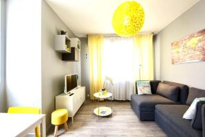 a living room with a couch and a tv at Le cocon coloré - centre ville - 50m de la gare in Annecy