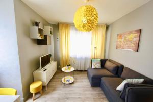 a living room with a couch and a tv at Le cocon coloré - centre ville - 50m de la gare in Annecy