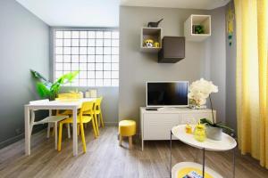 a living room with a table and a tv at Le cocon coloré - centre ville - 50m de la gare in Annecy +33 photos