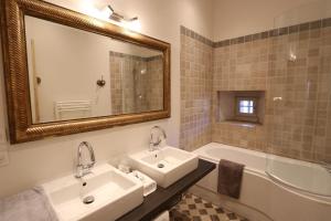 a bathroom with two sinks and a tub and a mirror at Historical villa by the lake - 12 people in Doussard