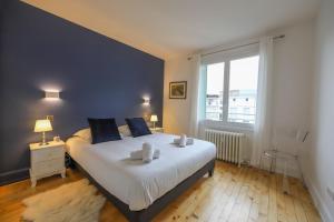 ein Schlafzimmer mit einem großen Bett und einem großen Fenster in der Unterkunft Le Boudoir bleu - 2 chambres in Annecy