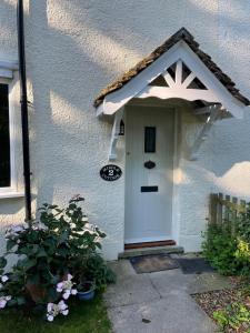 a white house with a white door with a star at Charming country cottage in quiet rural setting 