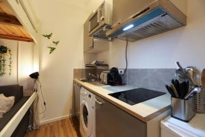 uma cozinha com um lavatório e uma máquina de lavar roupa em Le Petit Plus - studio confortable avec parking em Annecy
