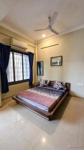 a bedroom with a large bed with blue curtains at Mystic Dreamville 3BHK Villa Lonavala in Lonavala