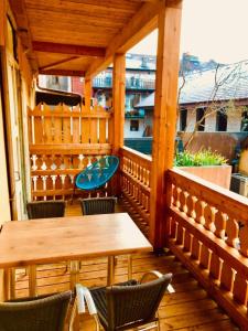 eine Holzterrasse mit Tischen und Stühlen auf dem Balkon in der Unterkunft Le Royale w balcony in Annecy