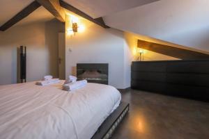 um quarto com uma grande cama branca e uma lareira em 2 bd apartment with sauna in the center of Annecy em Annecy