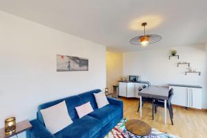 L'Avalanche - T2 avec parking في أنِسي: غرفة معيشة مع أريكة زرقاء وطاولة