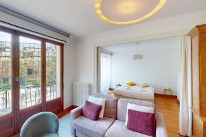 a bedroom with a bed and a couch with purple pillows at Le Favre - 2 chambres au centre in Annecy