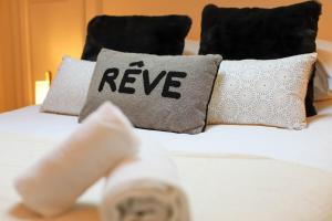 Una cama blanca con almohadas con las palabras revivir en Chez Maminou - 8 couchages parking proche centre en Annecy